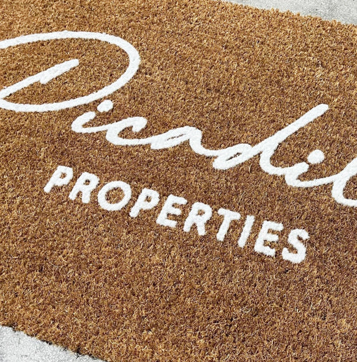 Close up image of Coir Embossed Logo Mat with White Embossed Logo