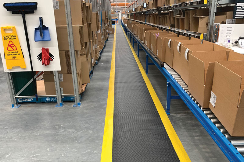 Insitu product image of black and yellow Diamond Plate Gel Anti-Fatigue Mat in packing warehouse