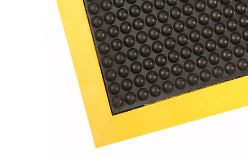 Corner image of the yellow and black on the OrthoStand Mat