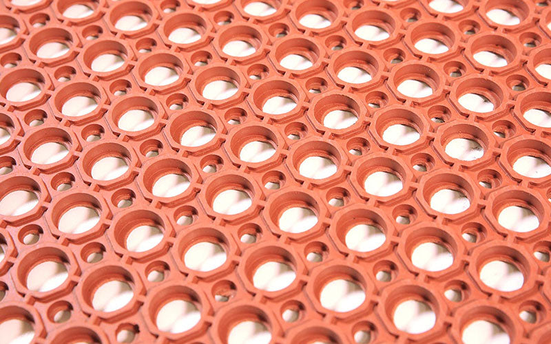 Close up of the drainage hole pattern of the nitrile rubber safewalk mat in terracotta