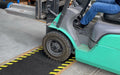 Insitu product image of non-slip, black and yellow Smartgrip Industrial matting Roll used in warehouse being driven over by forklift