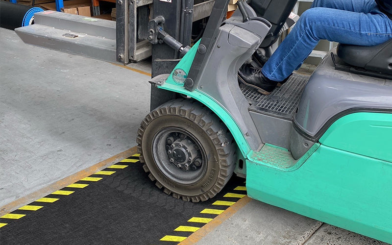 Insitu product image of non-slip, black and yellow Smartgrip Industrial matting Roll used in warehouse being driven over by forklift